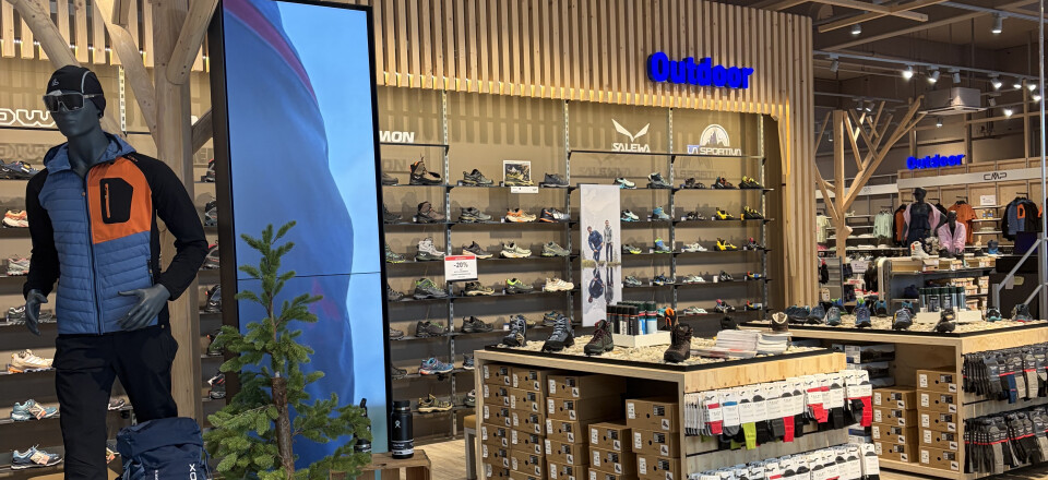 Innenansicht des Globetrotter Outdoor-Geschäfts mit einer Schaufensterpuppe, einem großen digitalen Display und umfangreichen Schuhabteilungen.